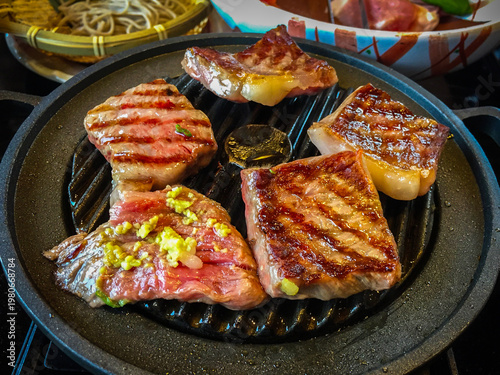 Large pieces of marbled wagyu beef grilled on a pan are a high quality and famous premium beef from Hida, Japan.