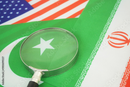 Flags of America, Pakistan and Iran under magnifying glass. Review negotiation of USA and Iran in Pakistan.