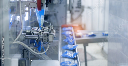 фотографія Blue bags moving along automated packing conveyor, milk food industry