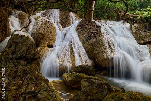 Scenic Waterfall Cascading Over Rocks in Lush Tropical Forest