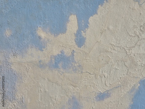 Abstract textured wall with peeling paint in soft blue and beige distressed surface background