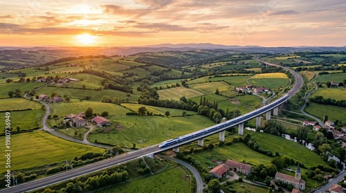 High-speed train on viaduct through rural landscape at sunset