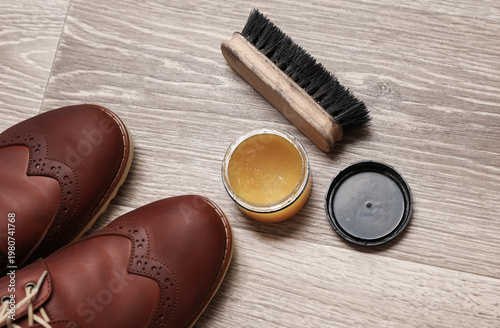 Fotografie Pair of brown men's brogue shoes and shoe care products on the floor