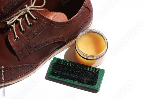 Tableau sur toile Pair of brown men's brogue shoes and shoe care products (cream and brush) on whi
