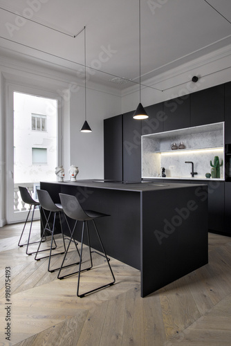 interior view of a modern bathroom in the foreground the masonry shower cubicle coated of marble of a modern isaland kitchen with wooden floor