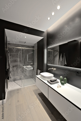 Interior of a modern bathroom with wooden flooring; in the foreground is the washbasin cabinet, and in the background is the shower enclosure
