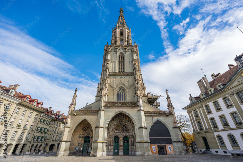 Obraz premium Berner Muenster gothic cathedral exterior facade with tall tower against blue sky. Bern, Switzerland.