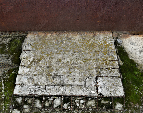 Cracked Concrete with Exposed Rusty Rebar and Moss