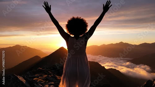 Woman arms outstretched against sunrise scenic landscape panoramic view
