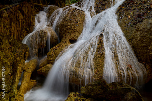 Scenic Waterfall Cascading Over Rocks in Lush Tropical Forest
