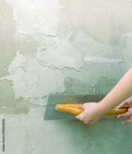 Wallpaper Mural Hands smooth plaster with a trowel on a textured wall Torontodigital.ca