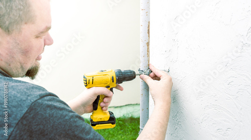 Wallpaper Mural Man works on a wall with a yellow drill Torontodigital.ca