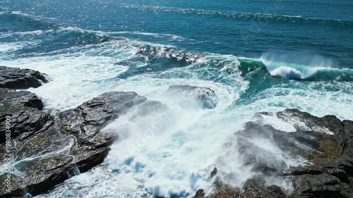 Ocean waves crashing against the rocks creating a beautiful scene.