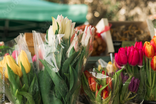 Close up of shopping basket with flowers on the local Farmers market. Shopping At Farmers Market Stall. Close up. Part of the series