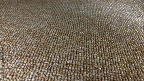 A close-up of a brown carpet texture with a dense, detailed grain pattern. This warm, natural look is perfect as a backdrop for modern interiors, decor, and design concepts.