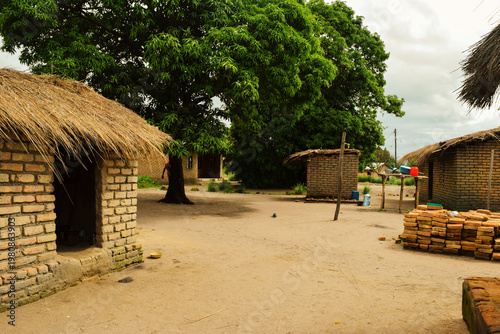 Fotografía Traditional Malawian Village Compound with Thatched Roof Mud Brick Houses at Kan