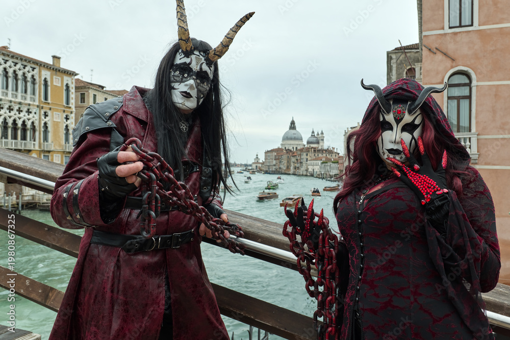 Naklejka premium Venice, Italy - February 16, 2026 - People dressed in masks for the Venice Carnival have their photos taken by tourists