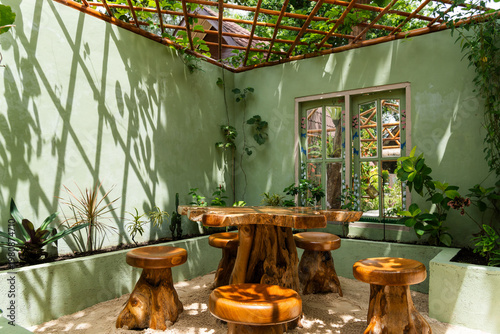 Cozy seating lounge with unique wooden table and stools in a green oasis