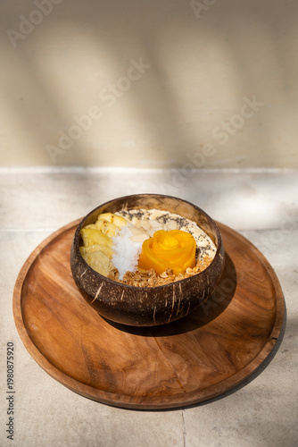 Healthy vegan smoothie bowl topped with mango, pineapple, granola, and seeds