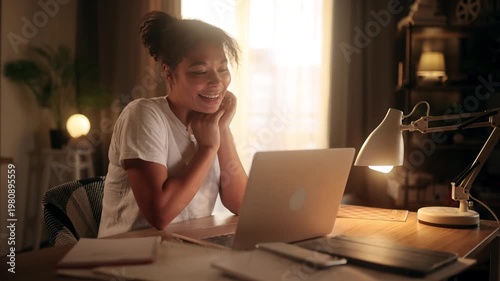 Flirty young african american woman talking on video call and smiling while looking at laptop