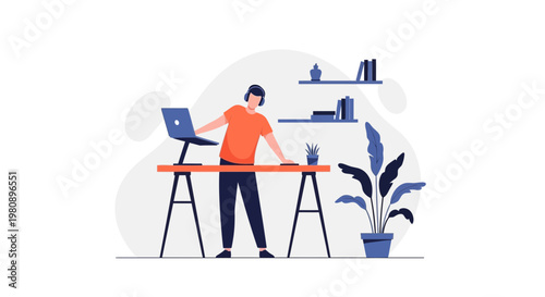 Man working at standing desk with laptop and headphones, home office setup