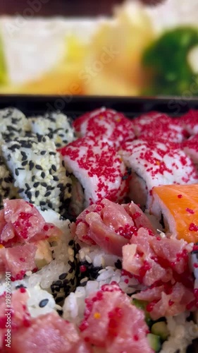 Philadelphia rolls, close-up sushi. Vertical video. Salmon sushi, assorted rice rolls. Ginger and chopsticks.