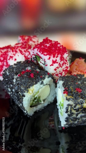 Philadelphia rolls, close-up sushi. Vertical video. Salmon sushi, assorted rice rolls. Ginger and chopsticks.