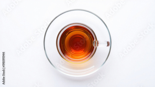 Obraz na plátně Top view of freshly brewed black tea in a clear glass cup and saucer on white ba