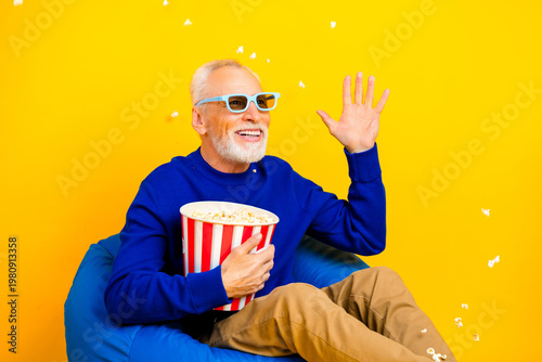 Cuadro en lienzo Senior man wearing 3D glasses enjoys popcorn while laughing and waving during a