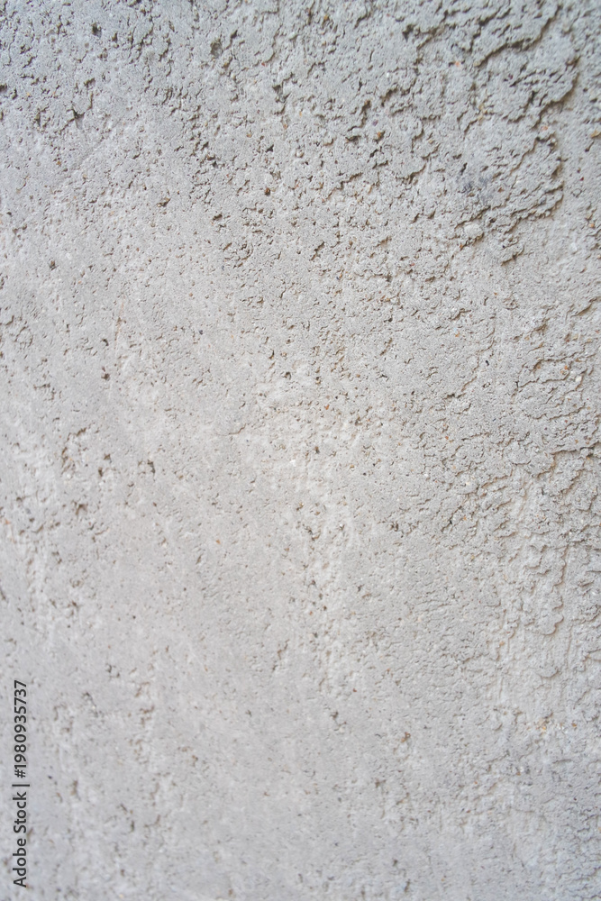 Fototapeta premium Close-up texture of a weathered grey concrete wall with peeling paint and cracked surface.