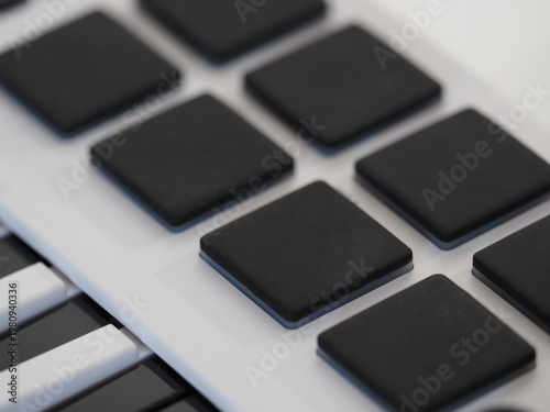 Pads on midi controller for creates drums. Selective focus.
