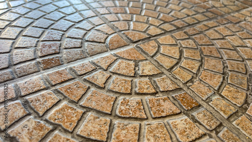 Textured circular tile surface with concentric grout lines on floor for architectural background and flooring design concept.