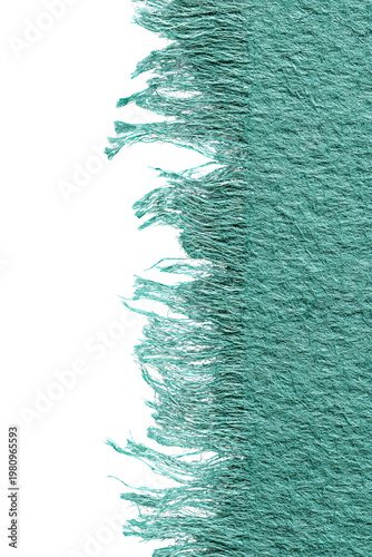 Torn edge of a teal-colored, textured surface against a contrasting black background