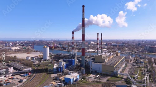 Industrial power plant with smoking chimneys by the sea port landscape during energy production and air pollution