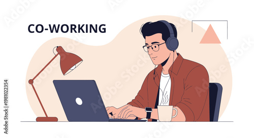 Young man working on laptop wearing headphones in a co-working space