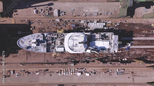 Modern yacht building process from above showing detailed deck structure and industrial shipyard equipment