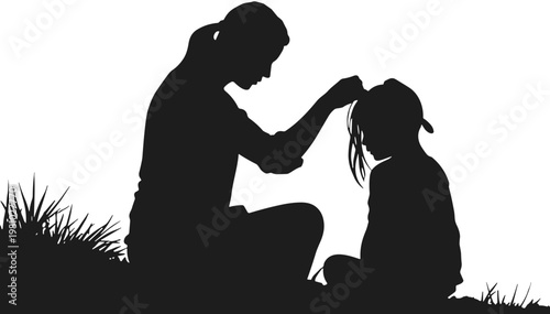 Mother and daughter silhouette sitting together in grass on Mother's Day  