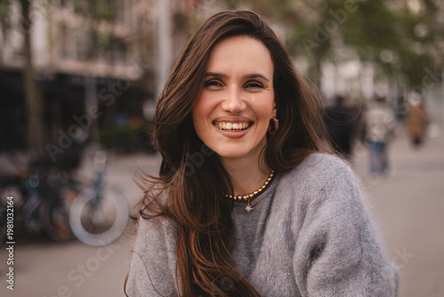 Fotografie Close-up of a charming young woman with a radiant toothy smile looking directly