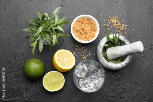 Tableau sur toile Mortar with pestle and ingredients for estragon lemonade on black table, flat la