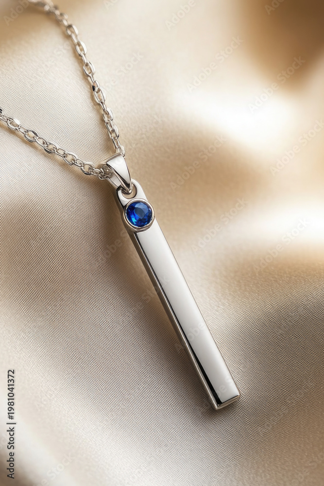 Fototapeta premium A close-up of a silver necklace featuring a blue stone. vertical frame
