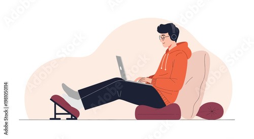Young man with headphones working on laptop while relaxing on comfortable seating