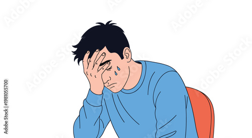 Stressed young man sitting and covering his face with his hand while crying or suffering from a severe headache.