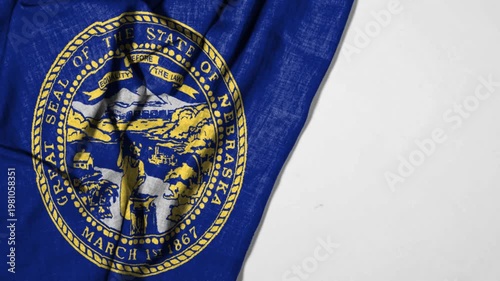 Nebraska State Seal Flag Emblem on Worn Blue Fabric Showing Historic Agricultural and Frontier Scene