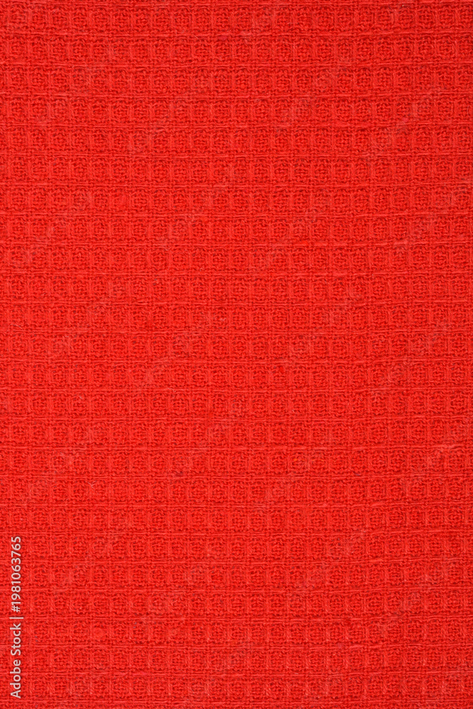Fototapeta premium A close up shot of a vibrant red cotton fabric featuring a classic waffle weave pattern with a textured surface 