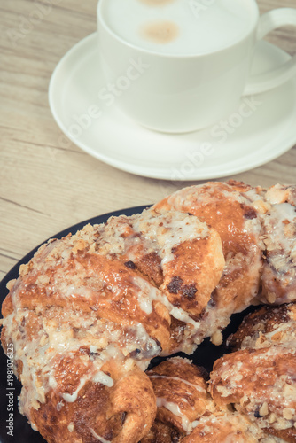 Traditional croissants with poppy seed filling and cup of coffee with milk. Dessert from polish city Poznan. Martin's croissant