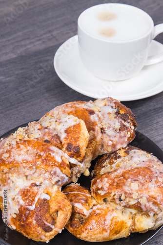 Traditional croissants with poppy seed filling and cup of coffee with milk. Dessert from polish city Poznan. Martin's croissant