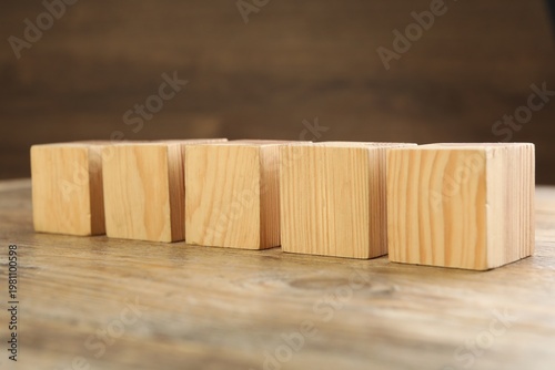 Blank cubes on wooden table, space for text