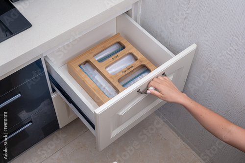 Canvas Print A high-angle lifestyle shot of a woman's hands opening a bright white kitchen dr