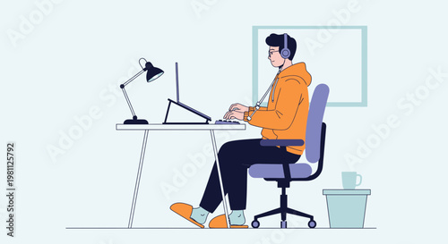 Young man working on laptop at desk with headphones, comfortable home office setup