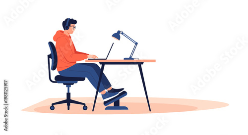 Young man working on laptop with headphones at desk, modern home office setup